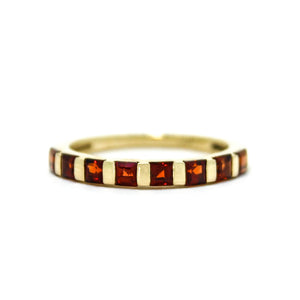 
            
                Load image into Gallery viewer, A product photo of a Multi-Square Garnet Ring in 9k Yellow Gold sitting on a plain white background. The 8 garnet stones measure 2.5mm across and are deep red, reflecting sanguine hues across their multi-faceted edges.
            
        