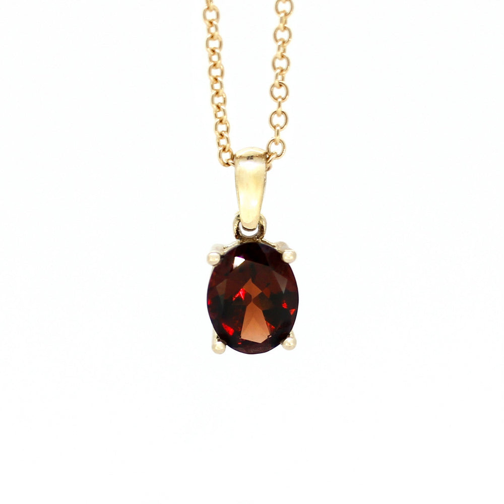 
            
                Load image into Gallery viewer, A product photo of a 9x7mm Oval Garnet Pendant in 9k Yellow Gold suspended against a white background. The impressively large and deeply-coloured oval-cut stone is contrasted by its overall minimalistic design, 4 simple golden claws holding the gem in place. It is suspended by a simple gold chain. The stone is a deep red, reflecting sanguine hues across its multi-faceted edges.
            
        