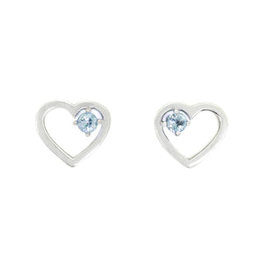 A product photo of two silver heart-shaped stud earrings sitting on a white background. A delicate, 2.5mm round aquamarine stone is nestled in the top right corner of each heart-shaped frame.