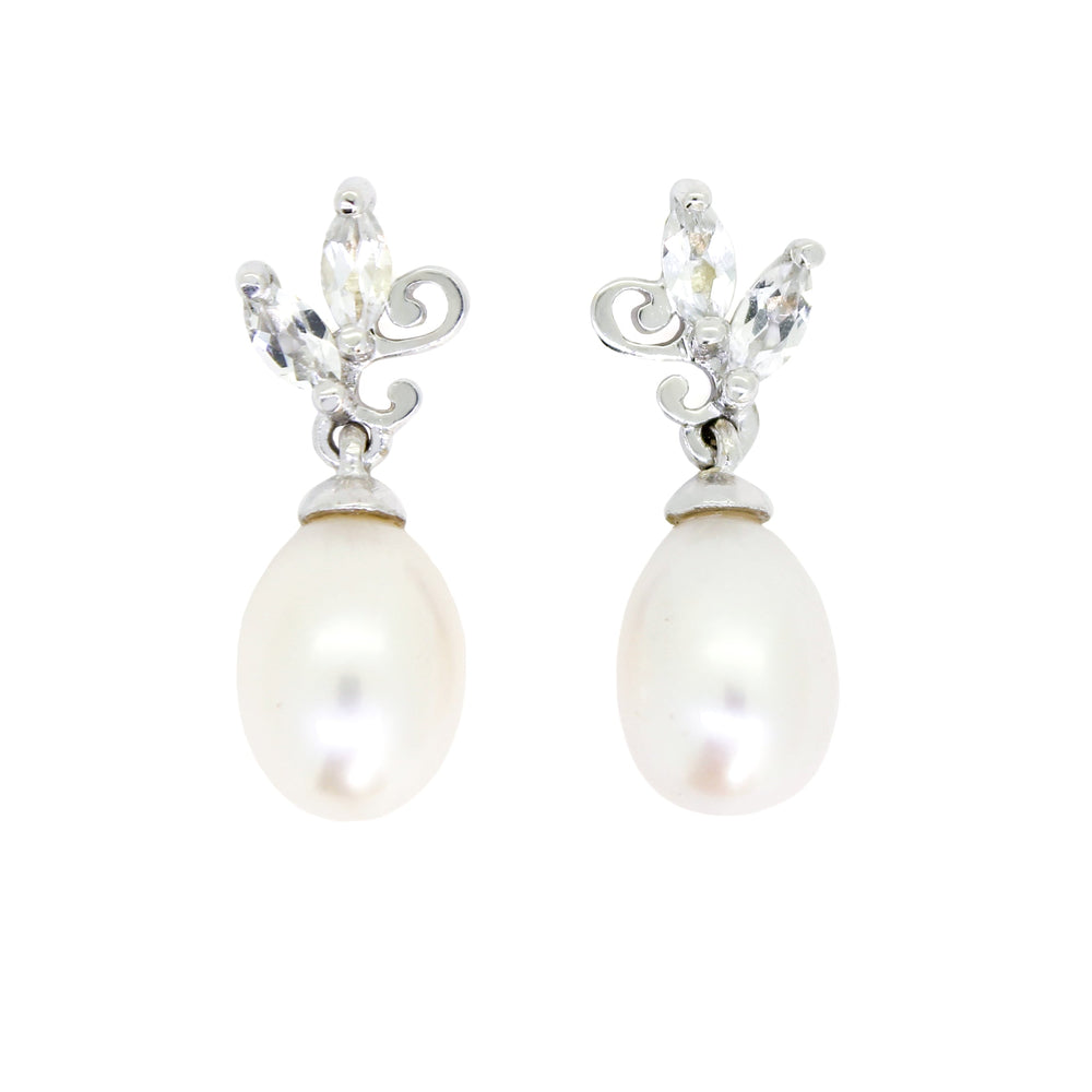 A product photo of a pair of ornate pearl drop stud earrings in white gold suspended over a white background. The large pearls are creamy white and teardrop-shaped, with two small marquise-cut silver topaz stones and subtle filigree detailing on each piece linking them to the back of the golden stud.
