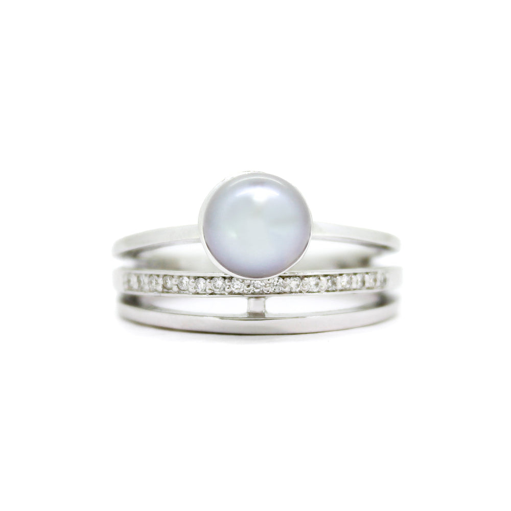 A product photo of a split-band steel-grey pearl ring with diamond detailing sitting on a white background.