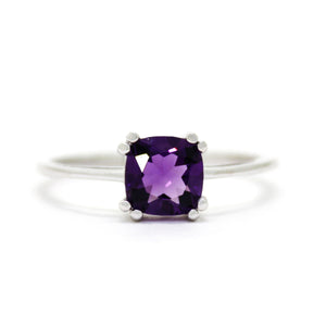 
            
                Load image into Gallery viewer, A product photo of a white gold ring with a large cushion-cut amethyst centre stone on a white background. The band is smooth gold, and the deep purple amethyst centre stone is held in place by 8 little claws, 2 on each corner.
            
        