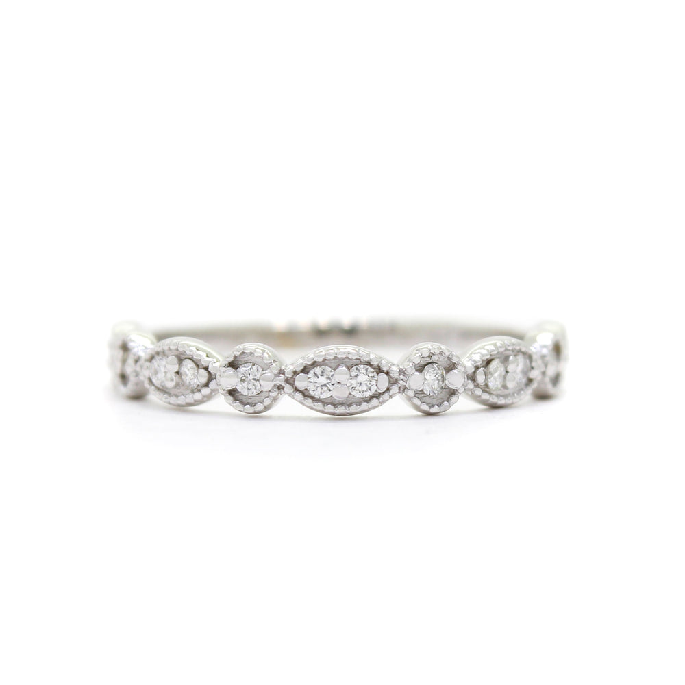 A product photo of an ornate diamond ring in 9k white gold. Oval white gold frames (adorned with two small diamonds each) alternate with circular frames (adorned with a single diamond each), and make up the ring for about half of its length before smoothing out into a simple white gold band.