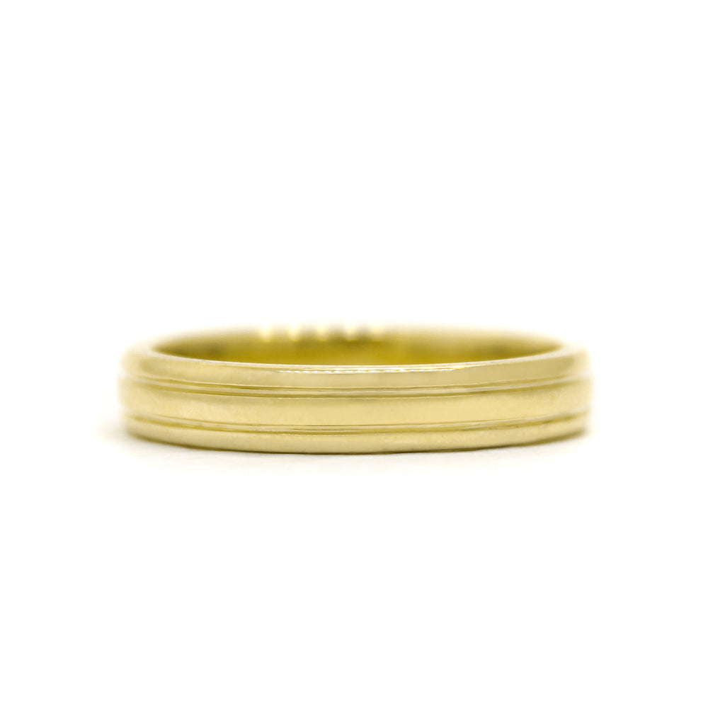 A product photo of a mens' ring made of 9k yellow gold. The band is 4mm tall and detailed with two polished grooves.