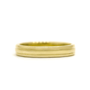 A product photo of a mens' ring made of 9k yellow gold. The band is 4mm tall and detailed with two polished grooves.