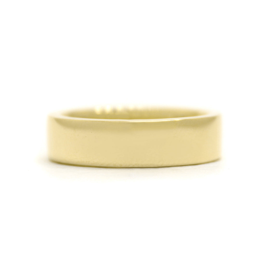 A product photo of a mens' ring made of 9k yellow gold. The flat band is 5mm tall and 1.5mm wide, making its squared edges thick and weighted.