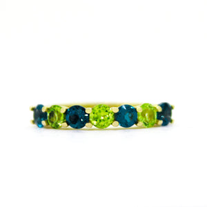 
            
                Load image into Gallery viewer, A product photo of a bold, alternating-gemstone ring in 9k yellow gold – made up of 7 3.5mm peridot and richly-coloured london blue topaz stones – sitting on a white background.
            
        