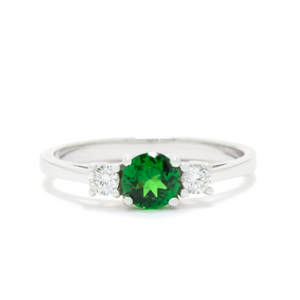 
            
                Load image into Gallery viewer, A product photo of a A uniquely elegant tsavorite and duo diamond ring in solid 9k white gold on a white background. The deep, verdant-green tsavorite centre stone held in place by 4 claws reflects light off of its many facets, as are the two diamonds on either side. The green gemstone colour be a good emerald substitute.
            
        