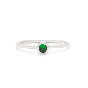 
            
                Load image into Gallery viewer, A product photo of a delicate white gold stacking ring with a tiny, bezel-set tsavorite in the centre sitting on a white background. The band is slim and thread-like, with the focus drawn to the petite 3mm glinting green centre stone. The green gemstone colour be a good emerald substitute.
            
        