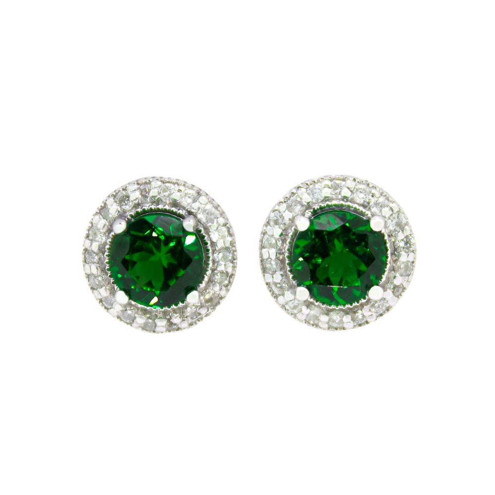 
            
                Load image into Gallery viewer, A product photo of a pair of white gold tsavorite earrings sitting against a white background. The pair of circle-cut green tsavorite are surrounded by thick frames of ornately detailed white gold and diamond detailing. The green gemstone colours make these earrings a good alternative or substitute for emerald.
            
        