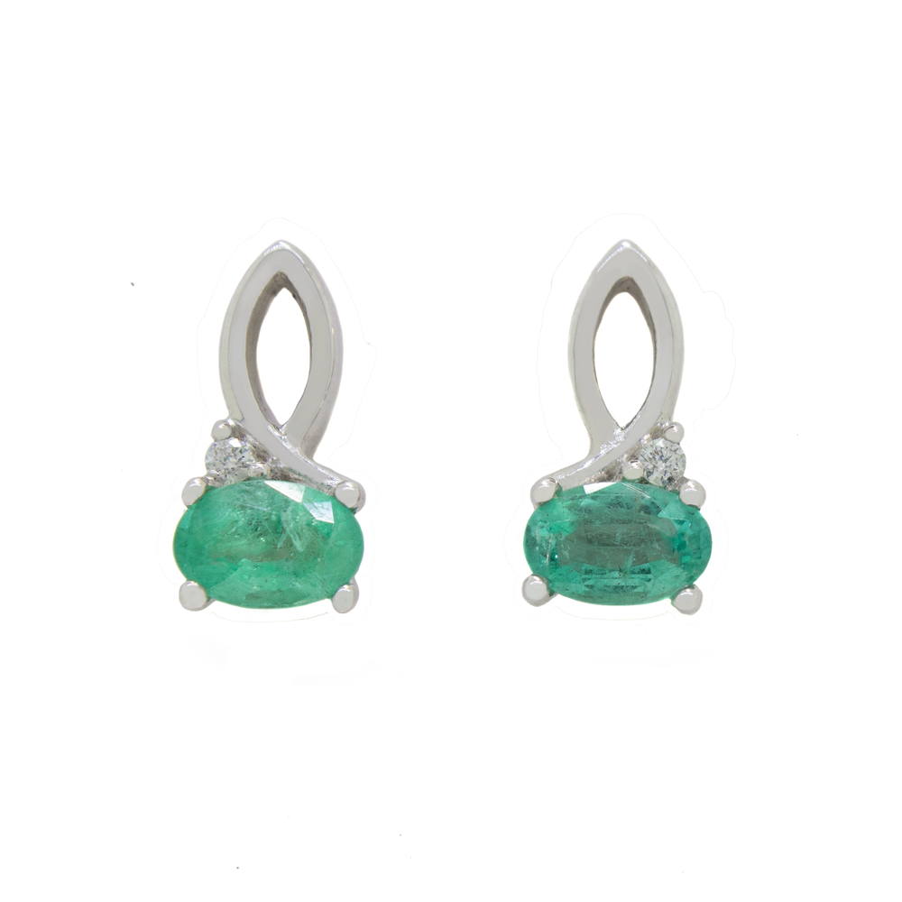 A product photo of a pair of emerald and diamond earrings in 9k white gold on a white background. The 6x4mm emeralds are horizontally-oriented, and hang by elegant loops of white gold - decorated with a single white diamond on the outer edge of each earring.
