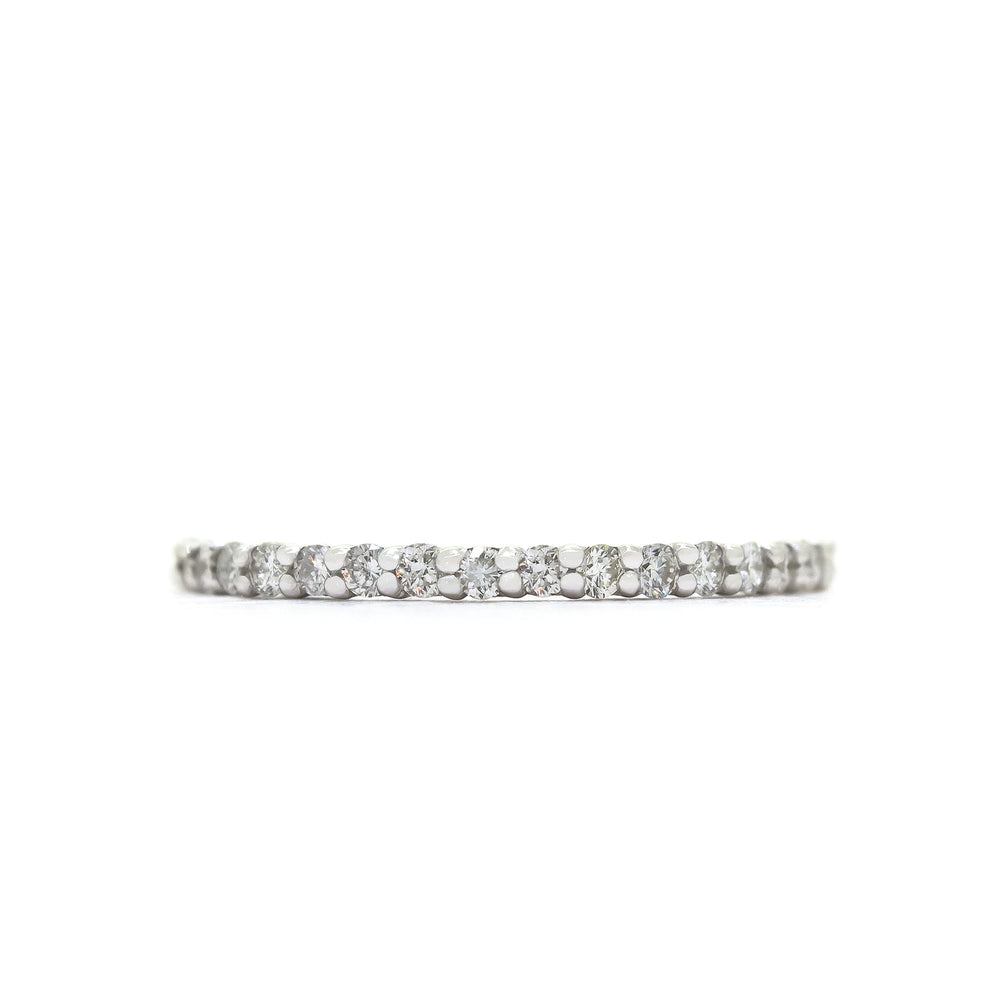 A product photo of a delicate, dazzling diamond eternity ring set in 9ct white gold. The ring is made up of 17 bright white diamonds set in a slim golden band.