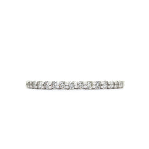 A product photo of a delicate, dazzling diamond eternity ring set in 9ct white gold. The ring is made up of 17 bright white diamonds set in a slim golden band.
