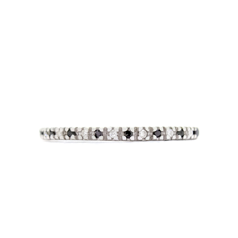 A product photo of a delicate, dazzling diamond eternity ring set in 9ct white gold. The ring is made up of alternating black and white diamond jewels that detail the entire circumference of the band.