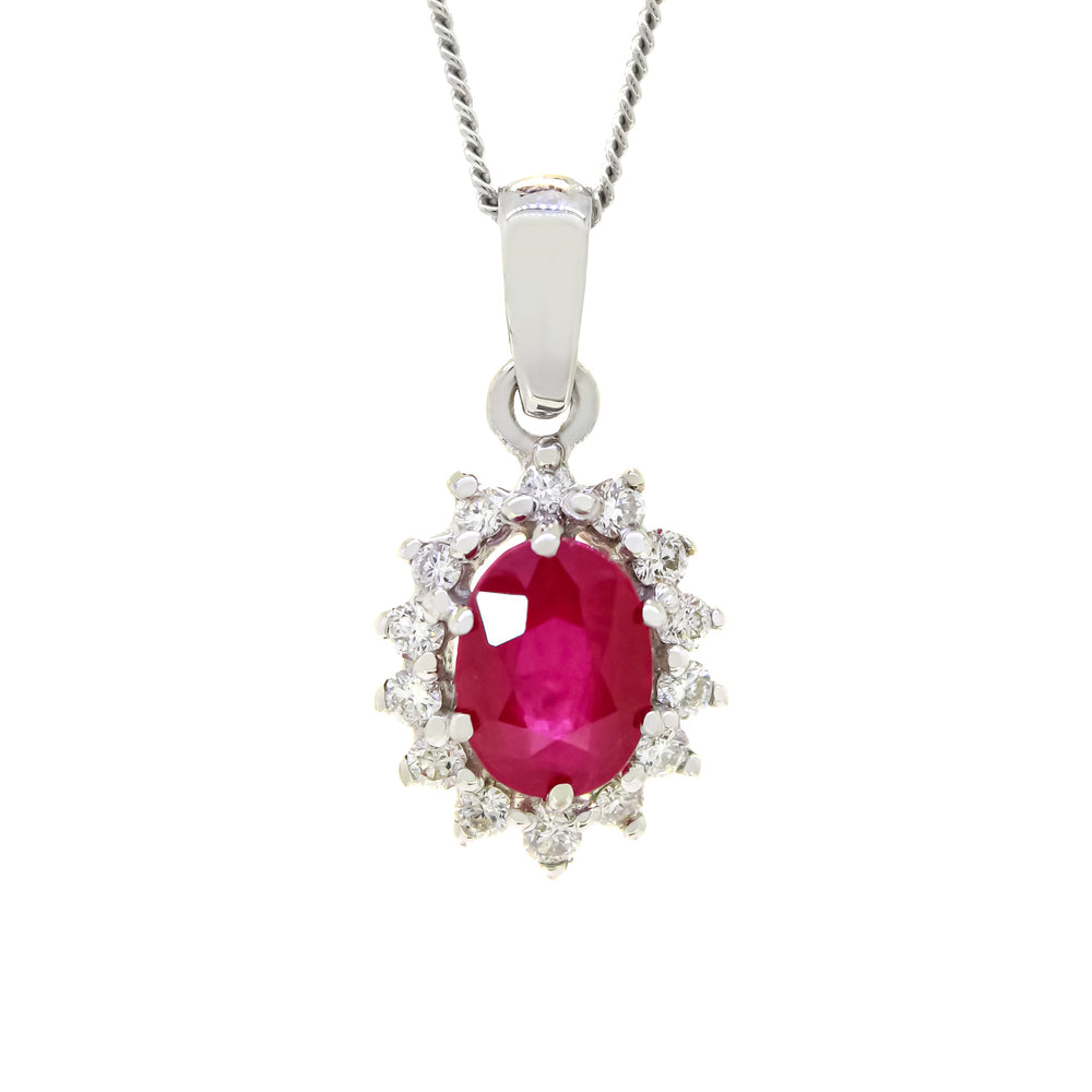 A product photo of a lavishly ornate ruby pendant bejewelled with a diamond halo suspended by a golden chain against a white background. The large ruby gemstone is oval-shaped, and is surrounded by a star-like halo of white gold and diamond details.