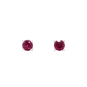 A product photo of two white gold stud earrings sitting on a white background. Held in place by 4 silver claws each are two dazzling round-cut purple grape garnet gemstones, reflecting shades of cool magenta light from their many edges.