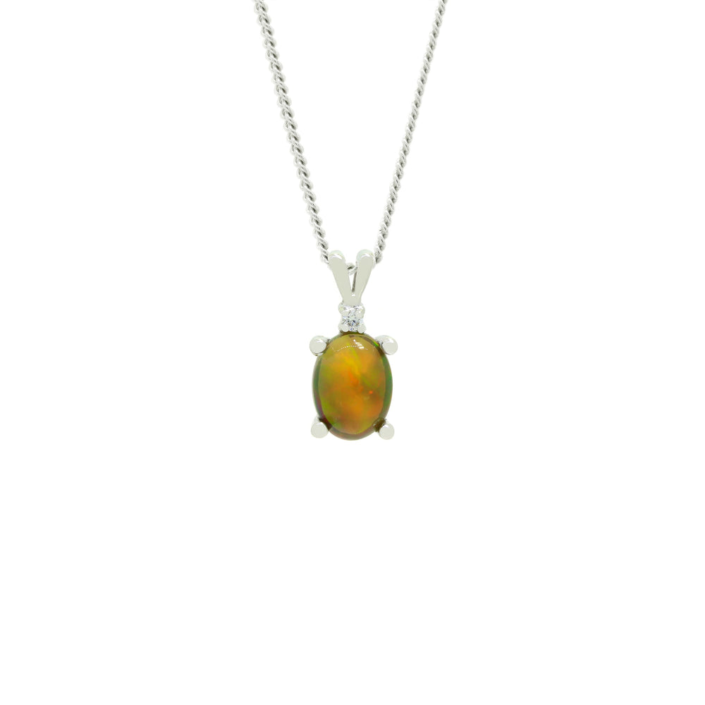 A product photo of an ethiopian opal pendant set in solid 9ct gold suspended by a golden chain over a white background. The dark, fiery opal stone shimmers with orange and green fire, and is topped a single white diamond.