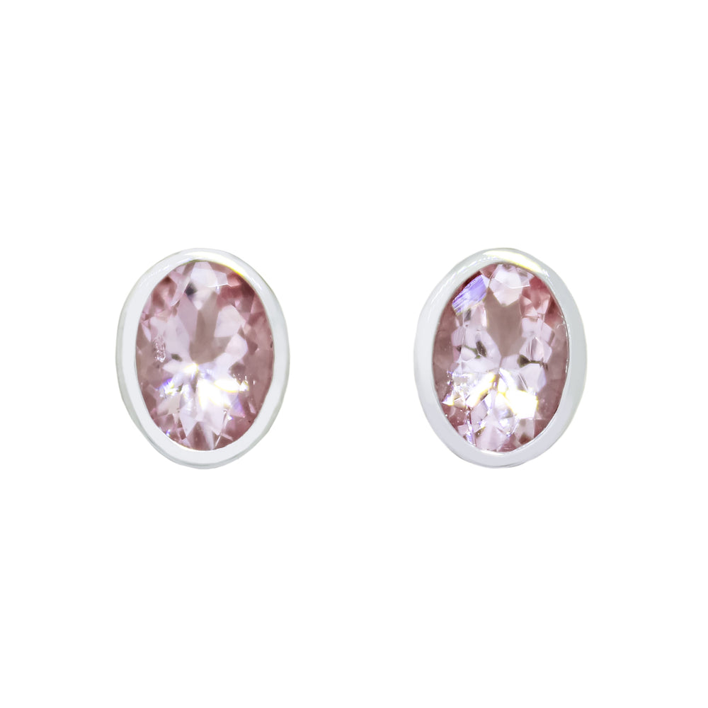 A product photo of a pair of morganite earrings in 9ct white gold sitting on a white background. The 7x5mm morganites are framed in a thick layer of white gold in a bezel setting.