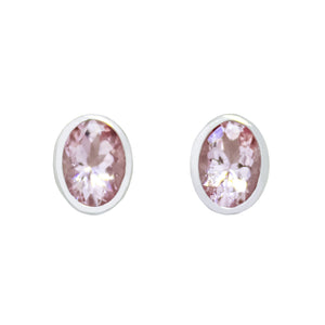 
            
                Load image into Gallery viewer, A product photo of a pair of morganite earrings in 9ct white gold sitting on a white background. The 7x5mm morganites are framed in a thick layer of white gold in a bezel setting.
            
        