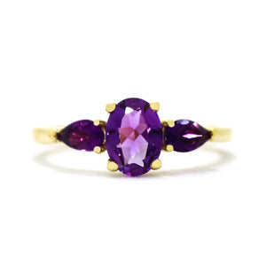 
            
                Load image into Gallery viewer, A product photo of a dainty and elegant yellow gold ring with a stunning trio of amethysts sitting against a white background. The largest of the stones sits in the centre, a 7x5mm amethyst - hugged by two smaller pear-shaped amethyst stones on either side.
            
        