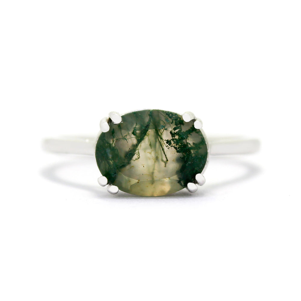 
            
                Load image into Gallery viewer, A product photo of a 9 karat white gold ring with an impressive oval moss agate centre stone sitting on a white background. The band is simple and rounded gold, with a single 10x8mm moss agate centre stone - adorned with moss-like, swirling dendritic inclusions. The moss agate stone is semi-opaque light olive colour, with striking mossy inclusions throughout.
            
        