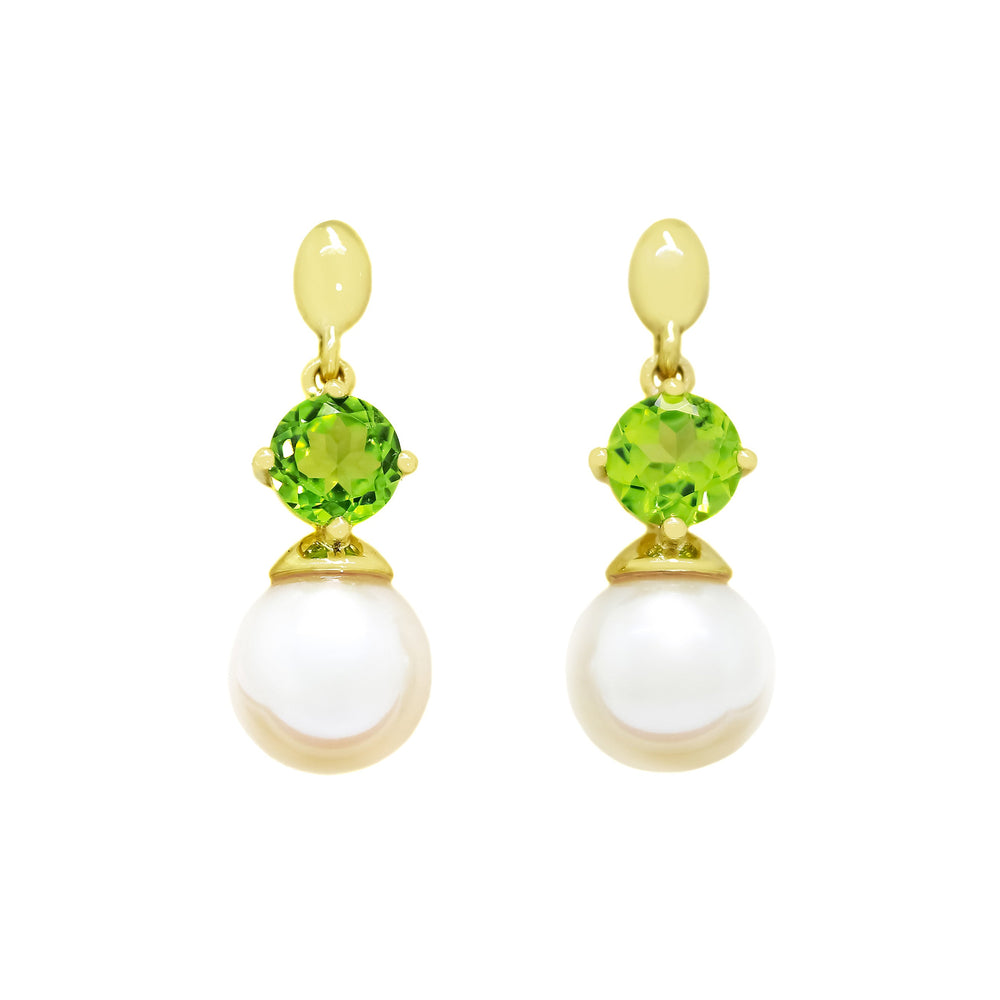 This product image features a pair of solid yellow gold gemstone and pearl earrings with a unique design. The main components are two chartreuse green peridot gems, each one set above a single rounded white pearl.