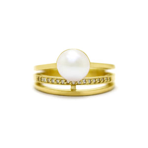 A product photo of a 9 karat yellow gold split-band white pearl pearl ring with diamond detailing sitting on a white background.