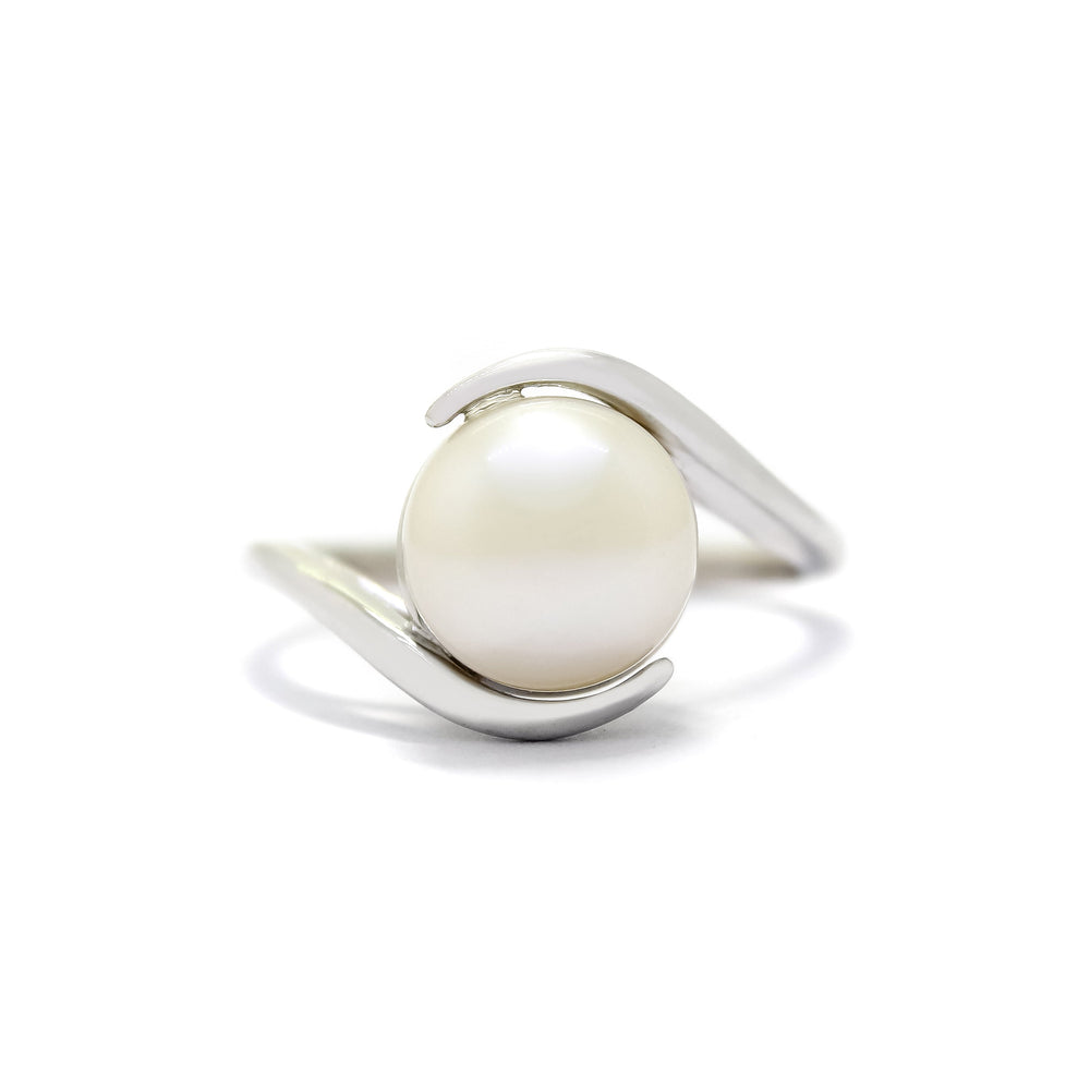 This product image shows a white gold pearl statement ring. The rounded pearl is an impressive 10mm size, and is held in place by a delicate split band on its top and bottom.