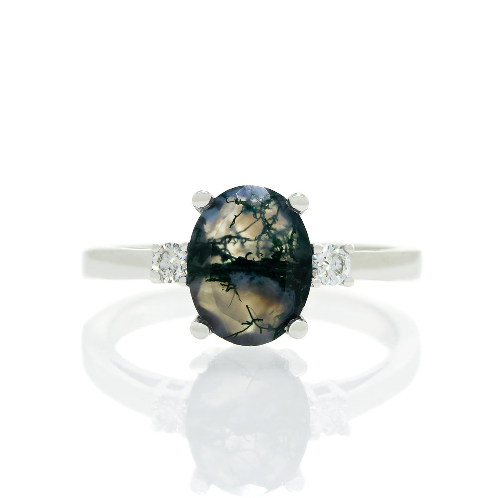 
            
                Load image into Gallery viewer, A product photo of a dainty and elegant white gold ring with a stunning trio of moss agate and diamonds sitting against a white background. The large centre stone is hugged by two smaller circular white diamonds on either side.
            
        