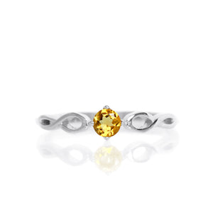 A product photo of an ornate silver ring with a citrine centre stone sitting on a white background. The silver band splits halfway along its length, becoming twisting and serpentine in appearance before meeting on either side of the dazzling orange 3.5mm stone, which is held in place by 4 silver claws.