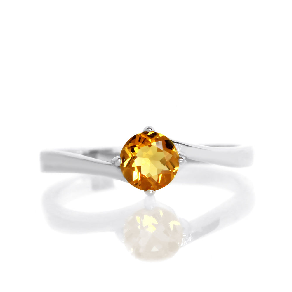 A product photo of a curved-band silver solitaire ring with an nright orange citrine centre stone sitting on a white background.