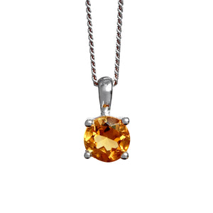 A product photo of a silver citrine pendant suspended by a chain against a white background. The round bright orange gemstone is held in place by 4 small claws.