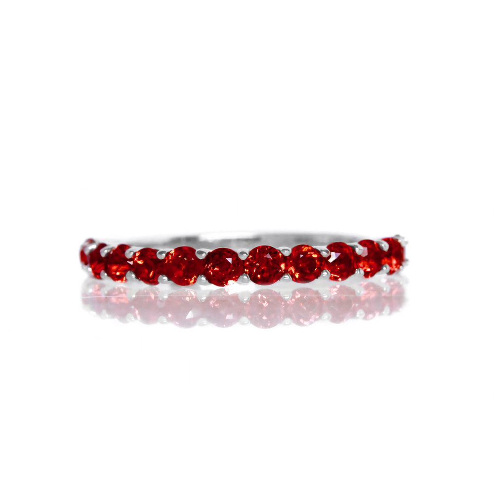 A product photo of a silver eternity band with 13 garnet stones embedded along its length on a white background. The deep red gemstone colour would be a good ruby alternative.