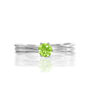 
            
                Load image into Gallery viewer, A product photo of a simple silver solitaire ring with a unique band detail and a 4mm round peridot centre stone sitting on a white background. The band is styled to appear as 3 little silver bands, tilted slightly outwards and &amp;quot;overlapping&amp;quot; towards the back of the ring.
            
        