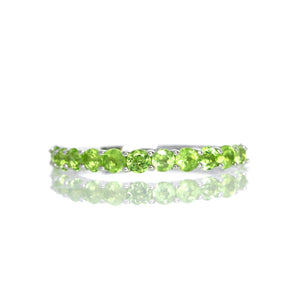 
            
                Load image into Gallery viewer, A product photo of a silver eternity band with 13 peridot stones embedded along its length on a white background.
            
        