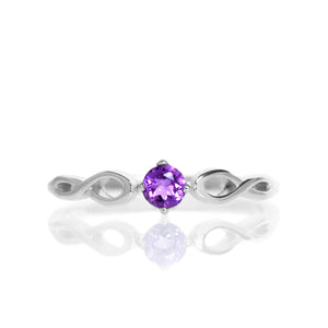 
            
                Load image into Gallery viewer, A product photo of an ornate silver ring with an amethyst centre stone sitting on a white background. The silver band splits halfway along its length, becoming twisting and serpentine in appearance before meeting on either side of the dazzling purple 3.5mm stone, which is held in place by 4 silver claws.
            
        
