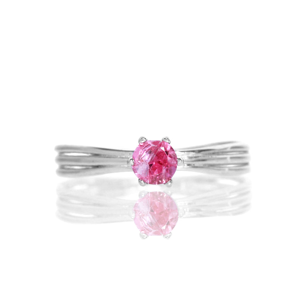 
            
                Load image into Gallery viewer, A product photo of a simple silver solitaire ring with a unique band detail and a 4mm round pink tourmaline centre stone sitting on a white background. The band is styled to appear as 3 little silver bands, tilted slightly outwards and &amp;quot;overlapping&amp;quot; towards the back of the ring.
            
        