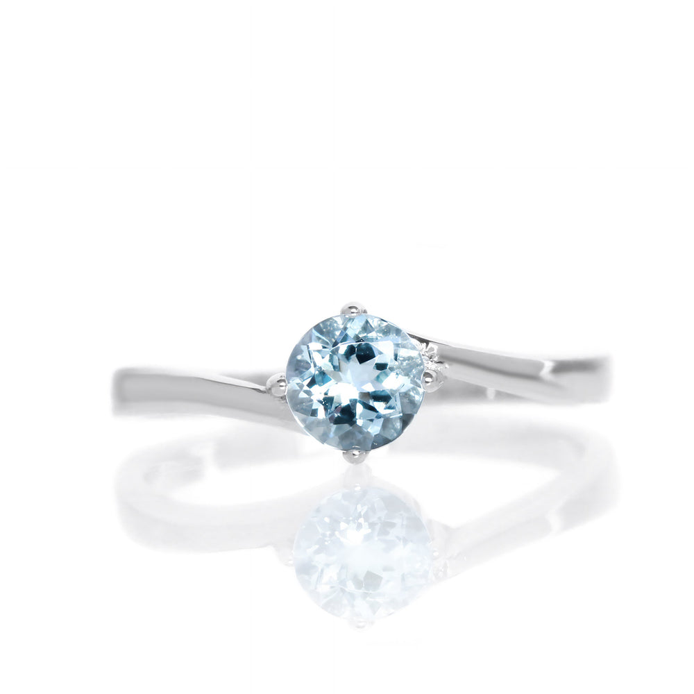 
            
                Load image into Gallery viewer, A product photo of a curved-band silver solitaire ring with a pale bllue aquamarine centre stone sitting on a white background.
            
        