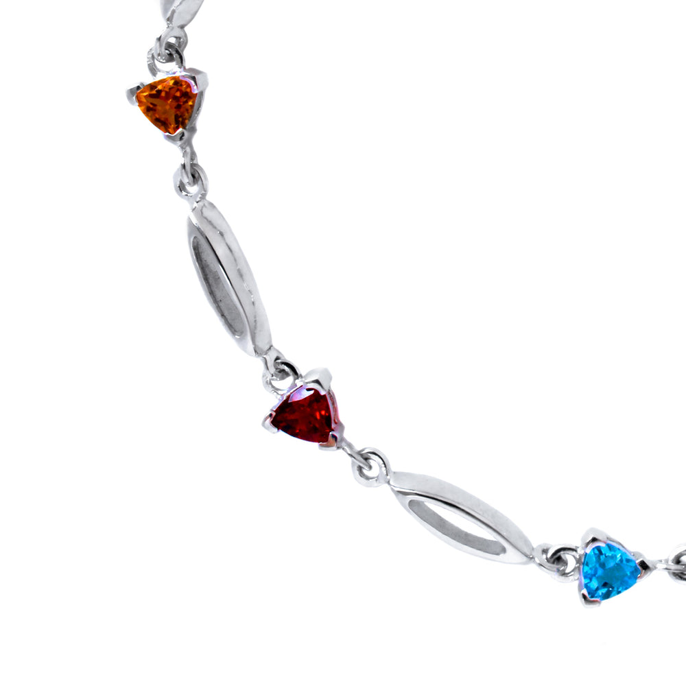 A product photo made up of a silver multi-gemstone bracelet featuring 4mm trilliant Blue Topaz, Garnet, Citrine, London Blue Topaz, Amethyst, Tanzanite, Peridot and Rhodalite, all interspersed with hollow silver marquise shapes.
