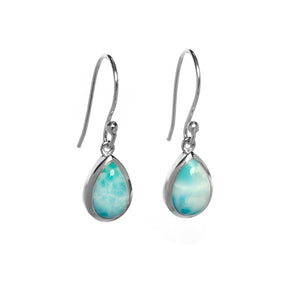A product photo of a pair of sterling silver Larimar drop earrings suspended against a white background. The drop earrings feature shepherd hooks, and the 9x6mm pear-shaped cabochon Larimars are held in place by silver bezel settings.