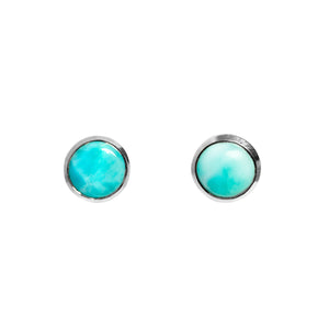 A product photo of a pair of silver Larimar gemstone stud earrings sitting against a white background. The 8mm round gemstones have dappled white and light blue patterning, similar to water reflections at the bottom of a pool, and are secured in place in bezel settings.
