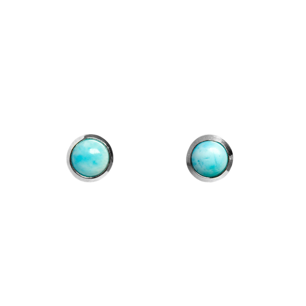 A product photo of a pair of silver Larimar gemstone stud earrings sitting against a white background. The 5mm round gemstones have dappled white and light blue patterning, similar to water reflections at the bottom of a pool, and are secured in place in bezel settings.