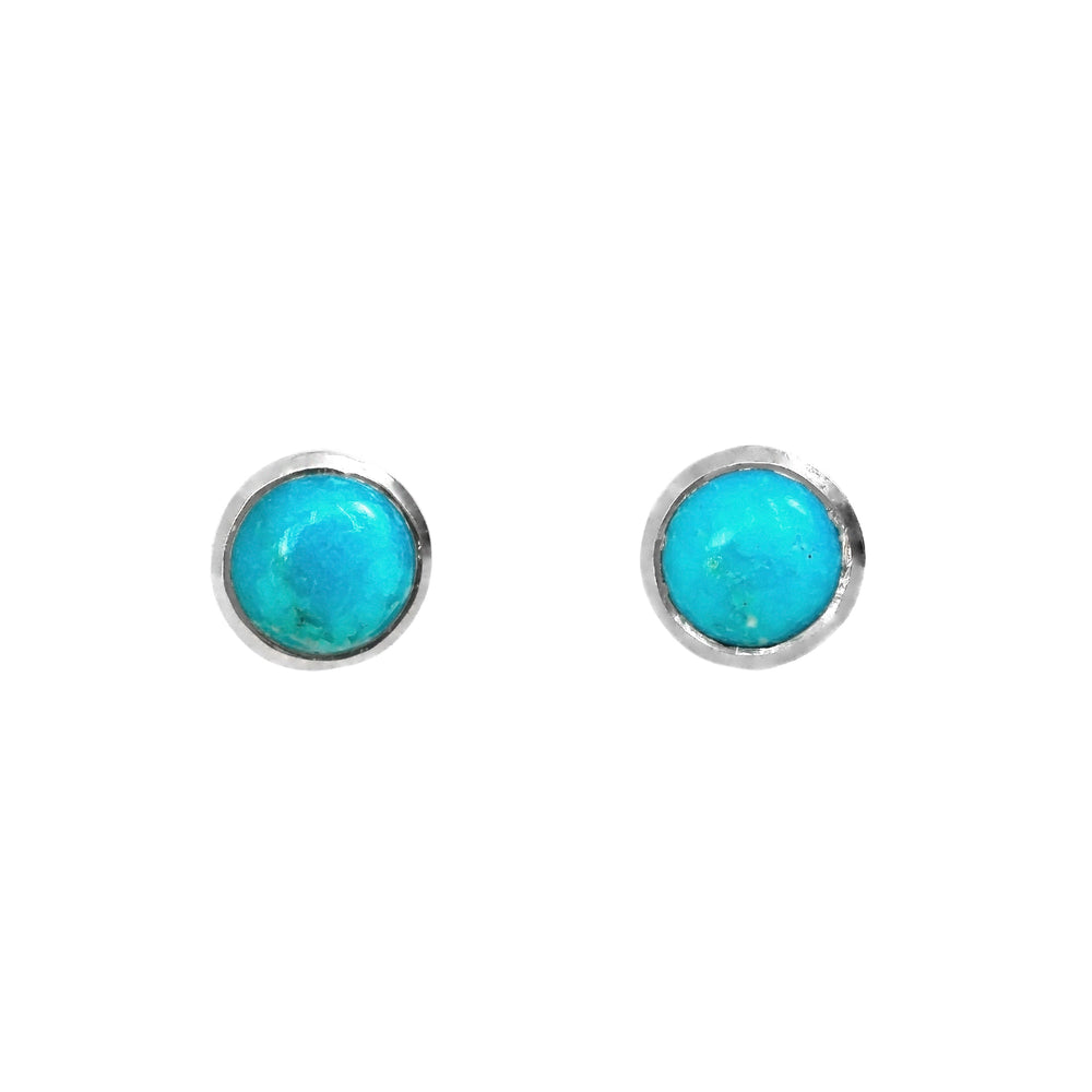 A product photo of a pair of silver Larimar gemstone stud earrings sitting against a white background. The 8mm round gemstones have dappled white and light blue patterning, similar to water reflections at the bottom of a pool, and are secured in place in bezel settings.