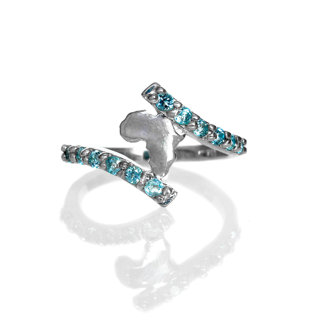 A product photo of a silver ring on a white background. The centre of the silver ring is composed of a cut-out of the African continent, framed at the top and bottom by two swooping lengths of silver, embedded with light blue aquamarine gemstones, that form the ring's band.