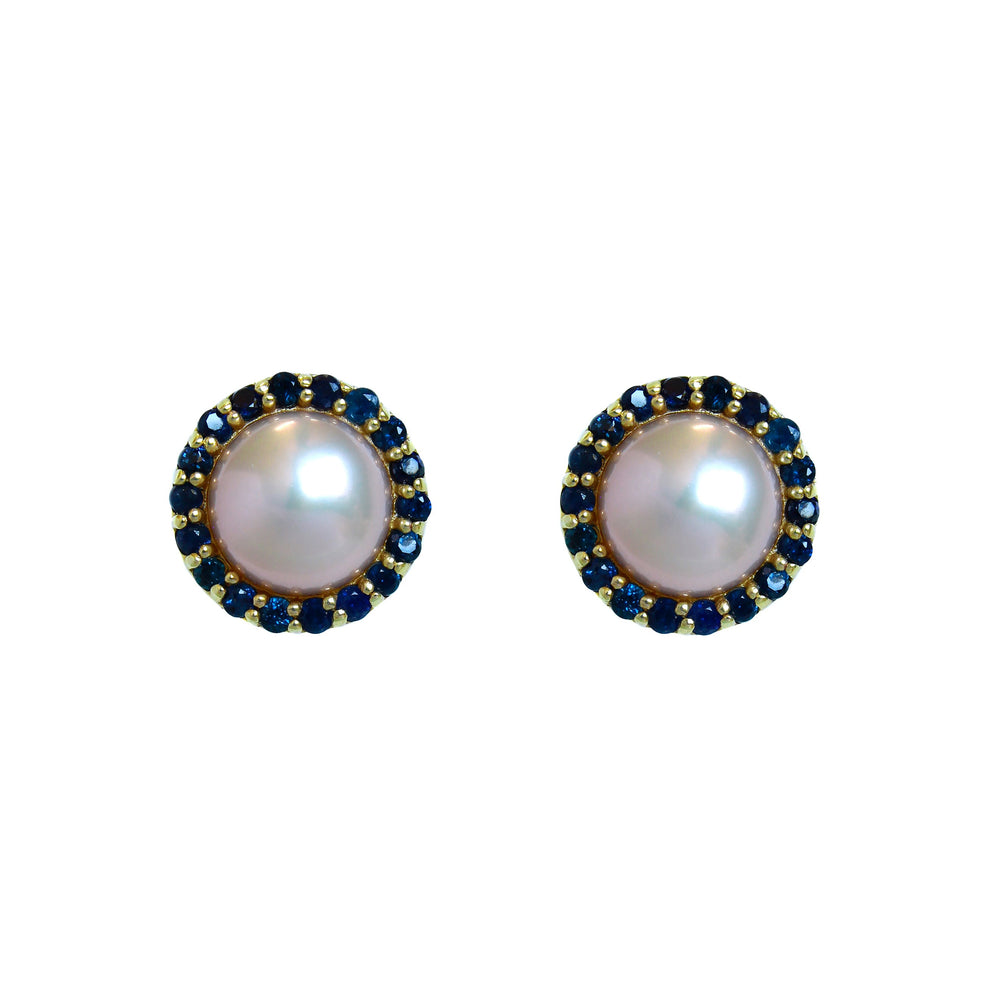 A product photo of a pair of 9 karat yellow gold sapphire halo pearl earrings on a white background. The are a soft, creamy white, and are surrounded by 18 dainty sapphire jewels.