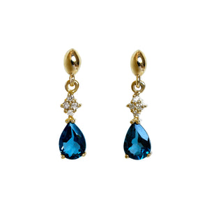 A product photo of 7x5mm Pear London Blue Topaz and Diamond Earrings in 9k Yellow Gold sitting on a plain white background. A golden cluster on each earring connects the peridots to the studs, each cluster adorned with 4 diamonds each.