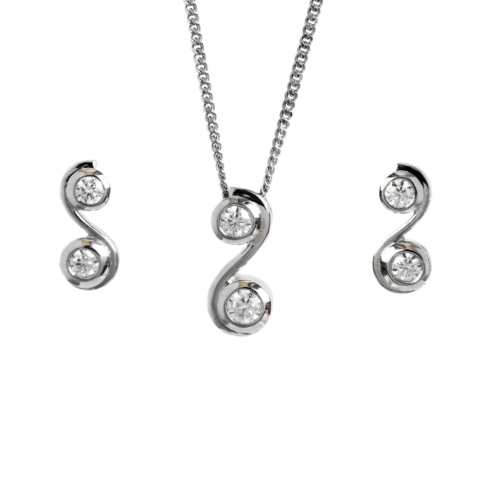 A product photo of a women's jewellery gift set in 9ct white gold and sparkling moissanite suspended against a white background. The white gold moissanite earrrings, each shaped like an "S" letter with a single sparkling moissanite nestled in each curve, sit on either side of a pendant of the same design suspended by a silver chain.