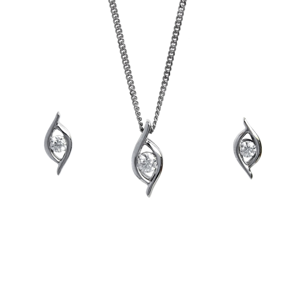A product photo of a women's jewellery gift set in 9ct white gold and sparkling moissanite suspended against a white background. The white gold moissanite earrrings, each made up of 2 curved lengths of gold curved in asymmetric elegance around a single dazzling moissanite, sit on either side of a pendant of the same design suspended by a silver chain.
